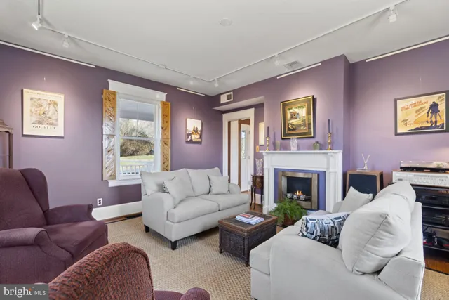 a living room with furniture a fireplace and a large window