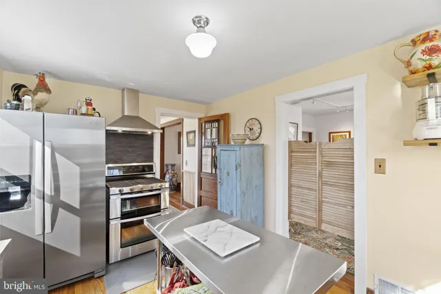a living room with stainless steel appliances kitchen island furniture and a window