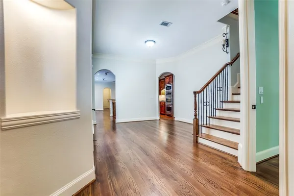 a view of a hallway with wooden floor and staircase