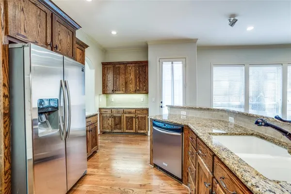 a kitchen with granite countertop a sink stove and refrigerator