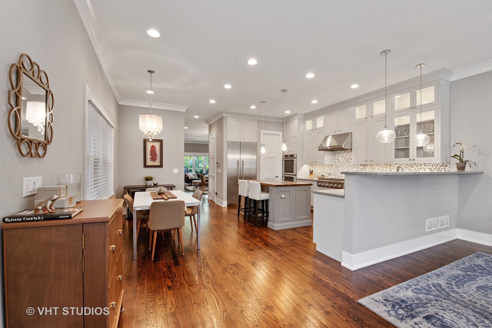 1734 West Henderson Street Chicago, IL 60657 - Photo 7 of 24 a large kitchen with kitchen island a sink a stove a dining table and chairs