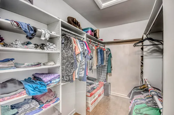 a view of walk in closet with clothes and shoes