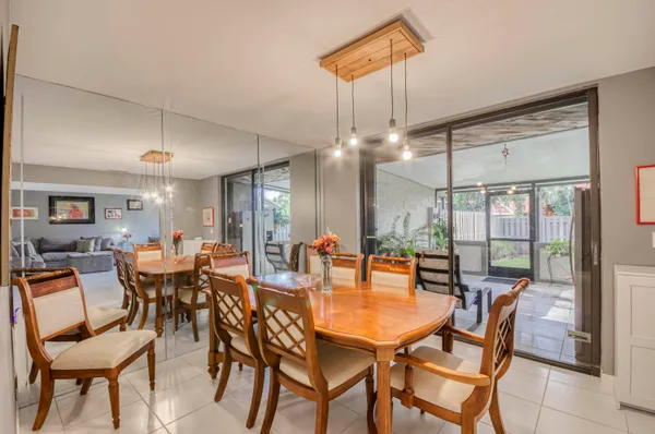 a view of a dining room and livingroom furniture wooden floor a chandelier