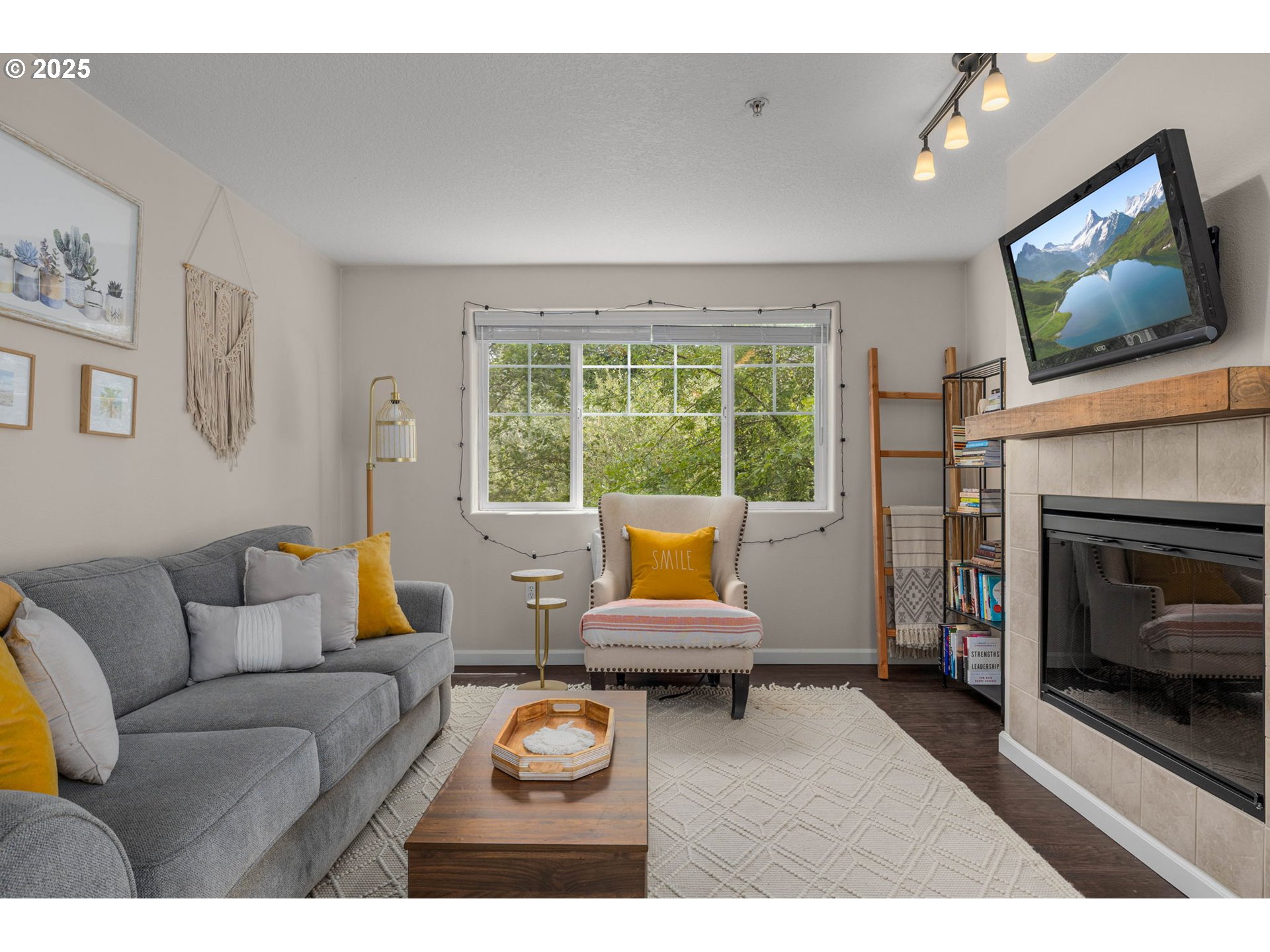 780 Northwest 185th Avenue, Unit 207 Beaverton, OR 97006 - Photo 5 of 29 a living room with furniture a fireplace and a flat screen tv