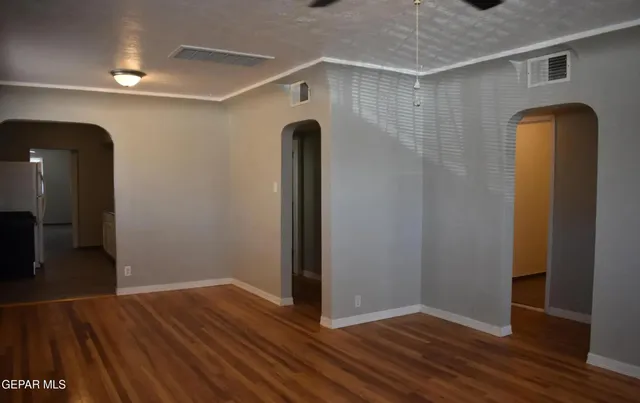 a view of empty room with wooden floor