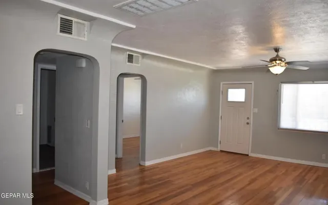 an empty room with a window and a ceiling fan