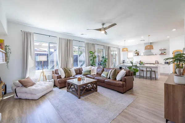 a kitchen with granite countertop a table chairs stove and refrigerator
