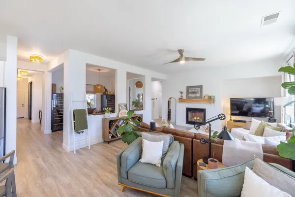 a kitchen with kitchen island granite countertop a sink a stove a refrigerator and chairs