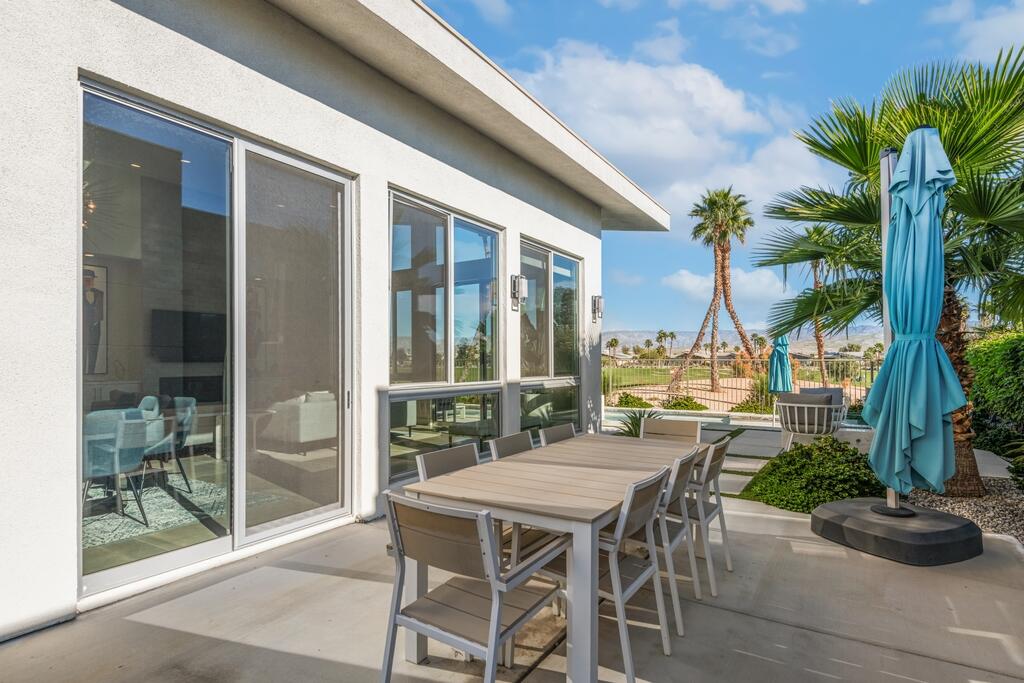 1200 Celadon Street Palm Springs, CA 92262 - Photo 33 of 47 a view of a patio with table and chairs potted plants and palm tree