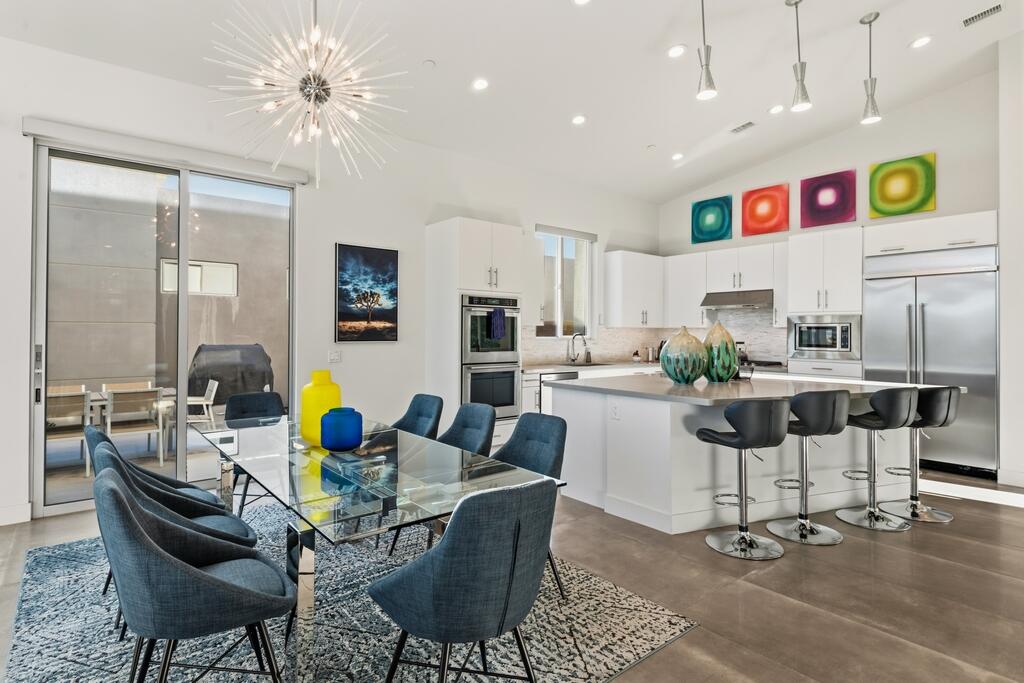 1200 Celadon Street Palm Springs, CA 92262 - Photo 7 of 47 a kitchen with stainless steel appliances kitchen island granite countertop a dining table and chairs