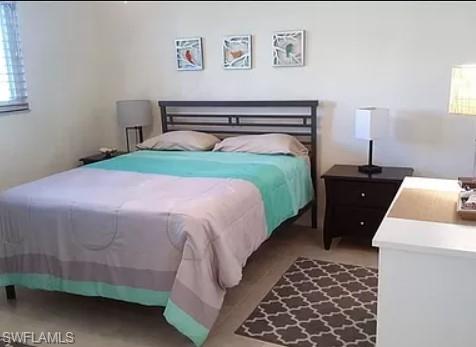 175 Turtle Lake Court, Unit 111 Naples, FL 34105 - Photo 11 of 19 a bedroom with a bed and a dresser