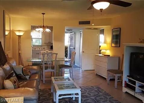 175 Turtle Lake Court, Unit 111 Naples, FL 34105 - Photo 5 of 19 a living room with furniture and a flat screen tv