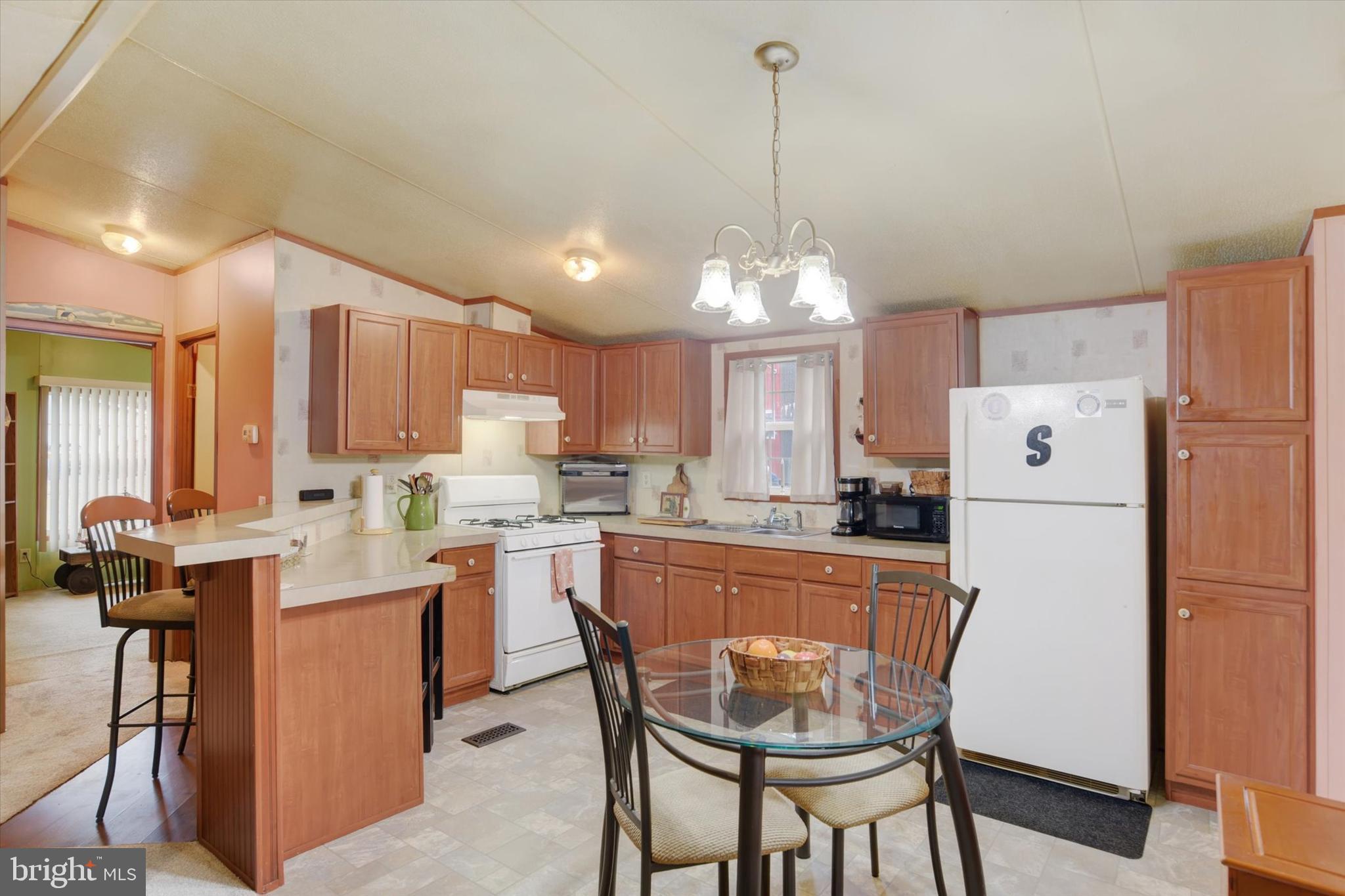 1 Rovak Drive Middletown, PA 17057 - Photo 3 of 18 a kitchen with a refrigerator a dining table and chairs