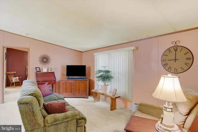 a living room with furniture a window and a flat screen tv