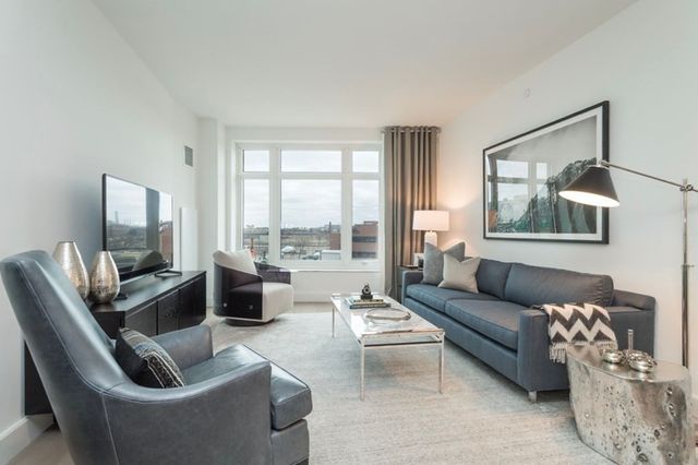 a living room with furniture and a floor to ceiling window