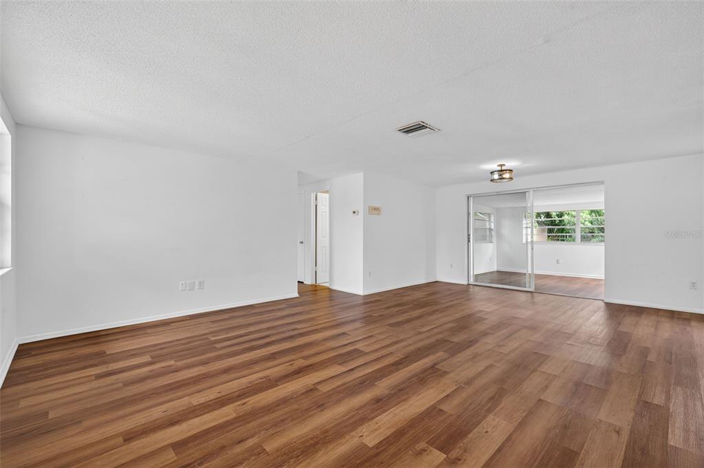 8626 Robilina Road Port Richey, FL 34668 - Photo 11 of 60 a view of empty room with wooden floor and fan
