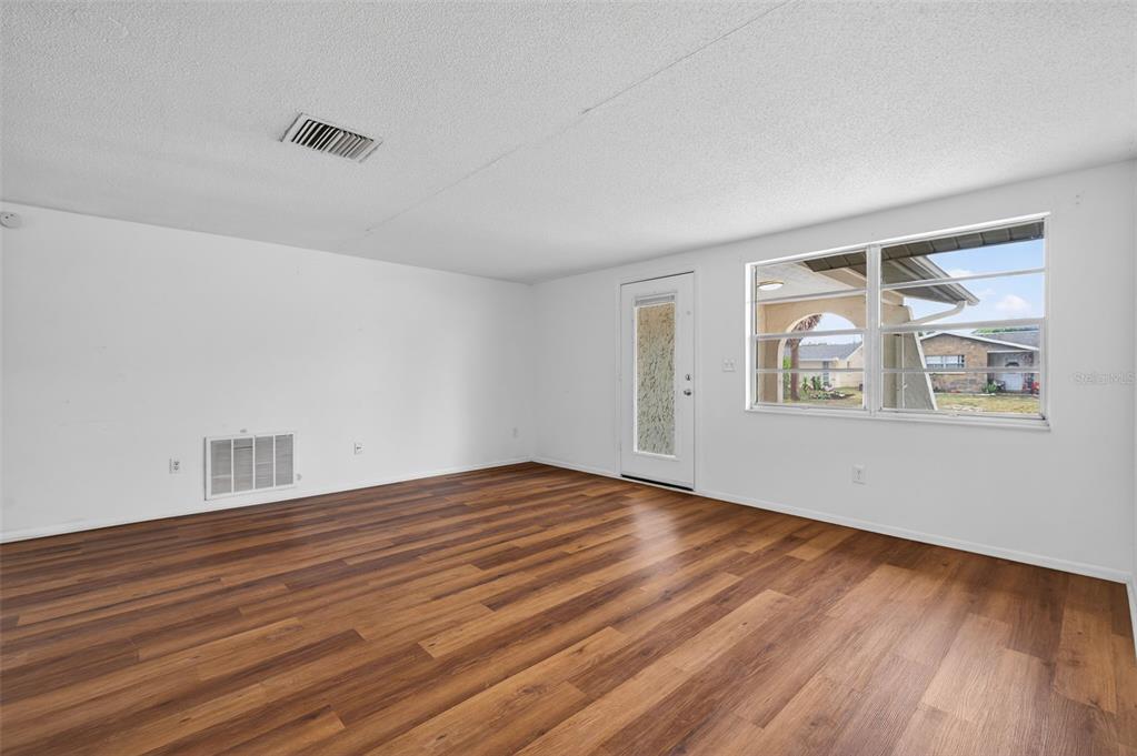 8626 Robilina Road Port Richey, FL 34668 - Photo 13 of 60 a view of an empty room with wooden floor and a window