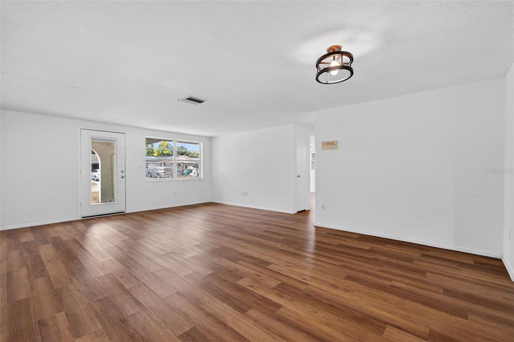 8626 Robilina Road Port Richey, FL 34668 - Photo 17 of 60 a view of empty room with wooden floor