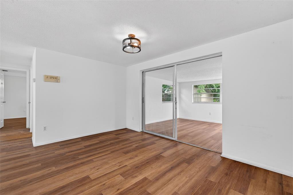 8626 Robilina Road Port Richey, FL 34668 - Photo 18 of 60 an empty room with wooden floor and windows