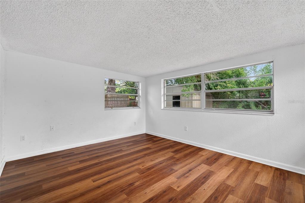 8626 Robilina Road Port Richey, FL 34668 - Photo 19 of 60 a view of an empty room with wooden floor and a window