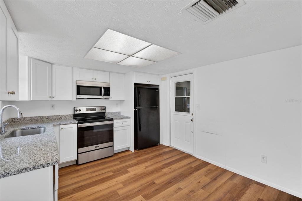 8626 Robilina Road Port Richey, FL 34668 - Photo 23 of 60 a kitchen with stainless steel appliances granite countertop a refrigerator stove microwave and sink