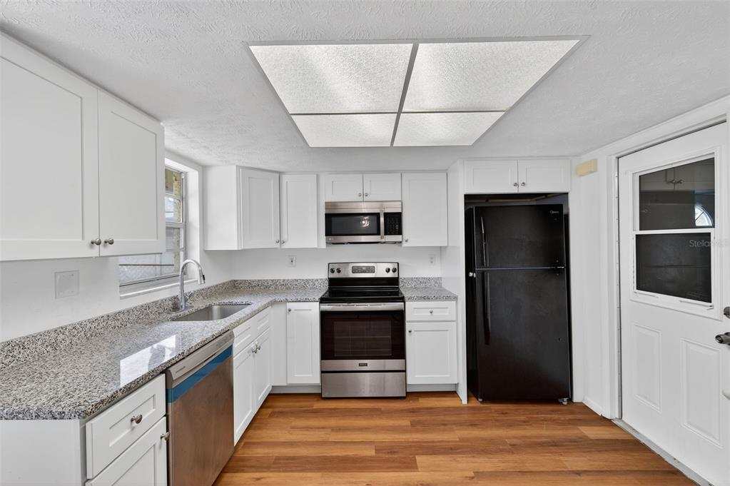 8626 Robilina Road Port Richey, FL 34668 - Photo 24 of 60 a kitchen with stainless steel appliances granite countertop a refrigerator and a sink