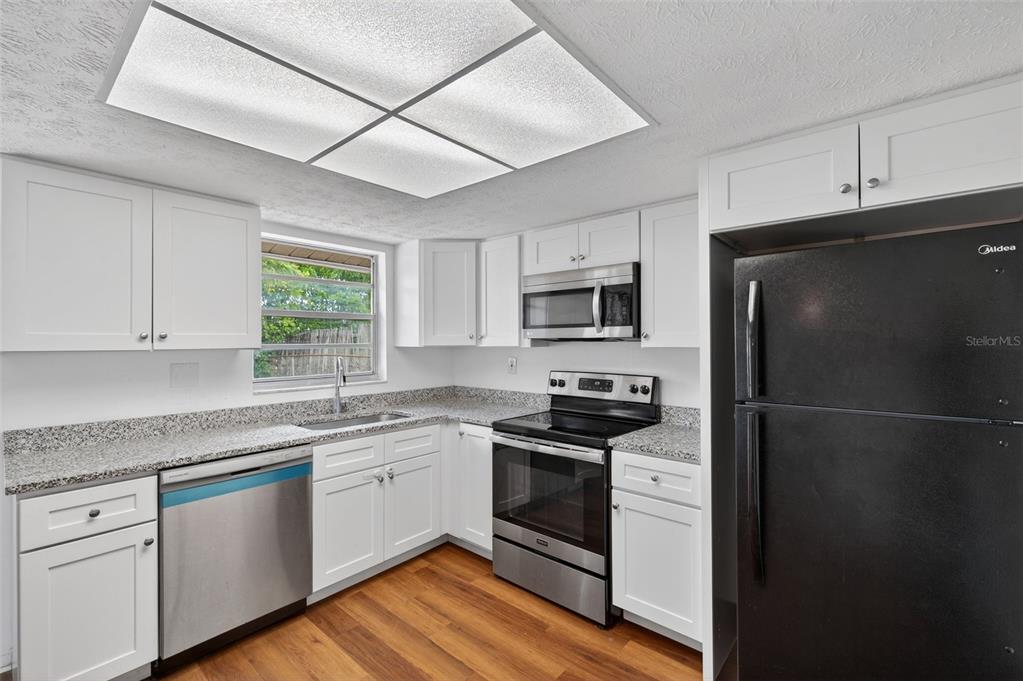 8626 Robilina Road Port Richey, FL 34668 - Photo 25 of 60 a kitchen with a white cabinets and white appliances