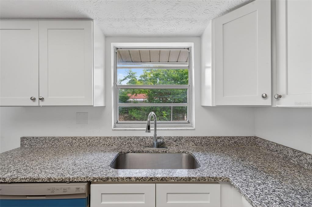 8626 Robilina Road Port Richey, FL 34668 - Photo 34 of 60 a kitchen with granite countertop a sink and a window