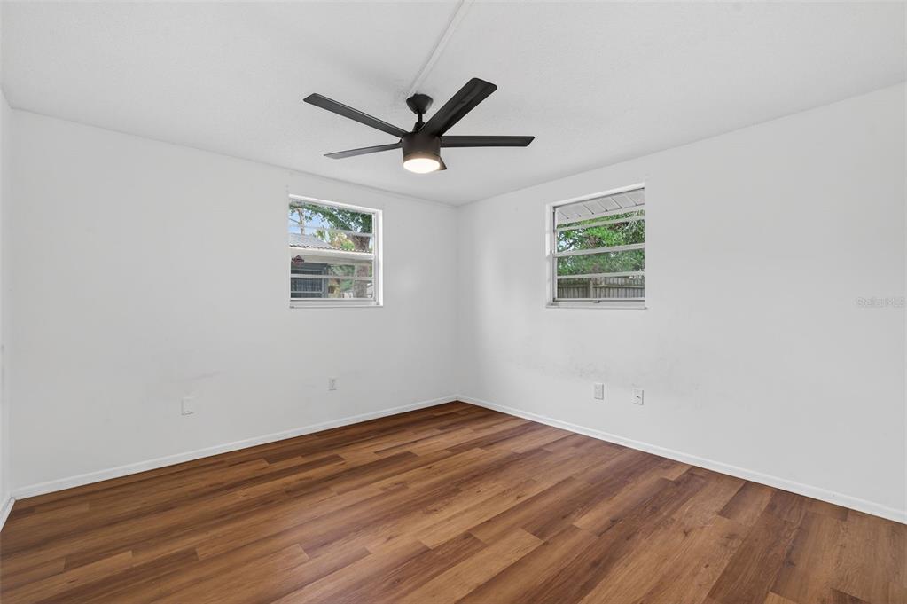 8626 Robilina Road Port Richey, FL 34668 - Photo 37 of 60 a view of empty room with wooden floor and fan