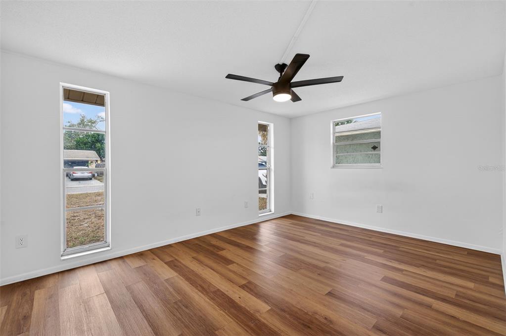 8626 Robilina Road Port Richey, FL 34668 - Photo 41 of 60 a view of empty room with wooden floor and fan