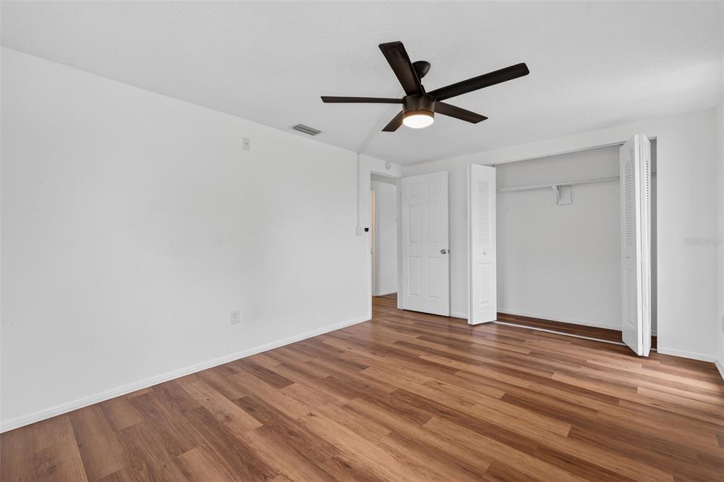 8626 Robilina Road Port Richey, FL 34668 - Photo 43 of 60 a view of a big room with wooden floor ceiling fan
