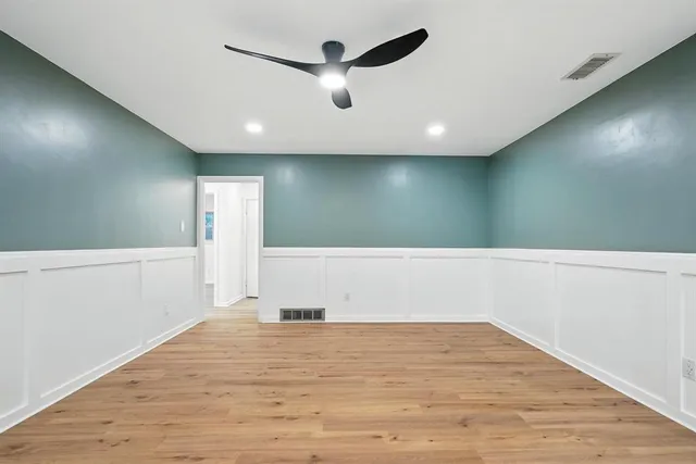 a view of empty room with wooden floor