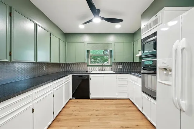 a kitchen with a white cabinets and refrigerator