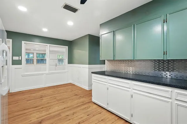 a kitchen with granite countertop wooden cabinets and white appliances