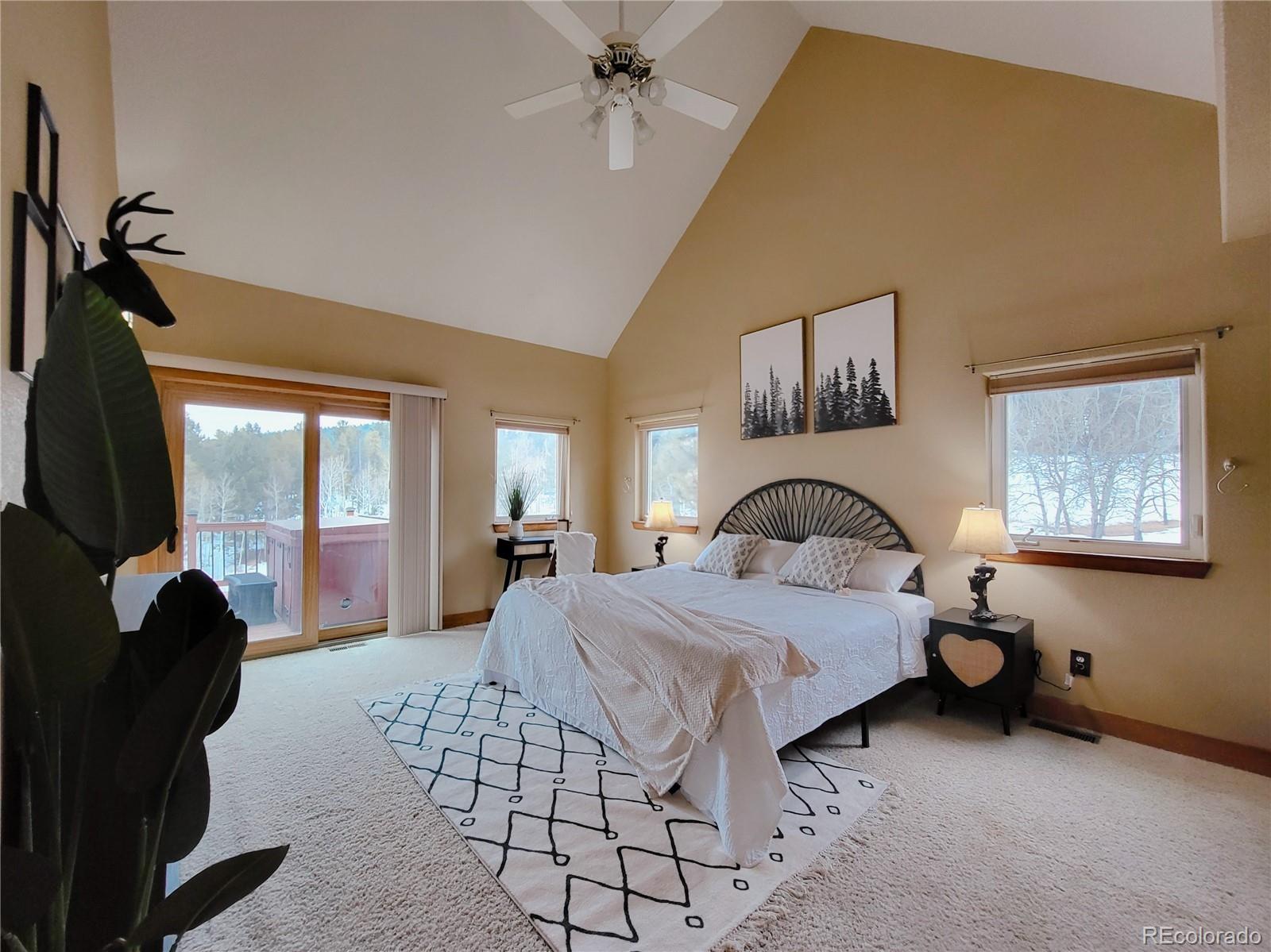 20133 Silver Ranch Road Conifer, CO 80433 - Photo 14 of 40 a bedroom with a bed and a chandelier