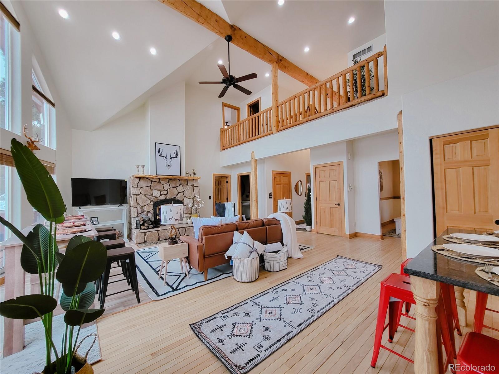20133 Silver Ranch Road Conifer, CO 80433 - Photo 2 of 40 a living room with fireplace furniture and a flat screen tv