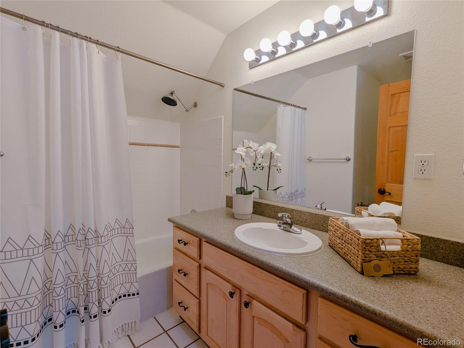20133 Silver Ranch Road Conifer, CO 80433 - Photo 21 of 40 a bathroom with a double vanity sink and a mirror