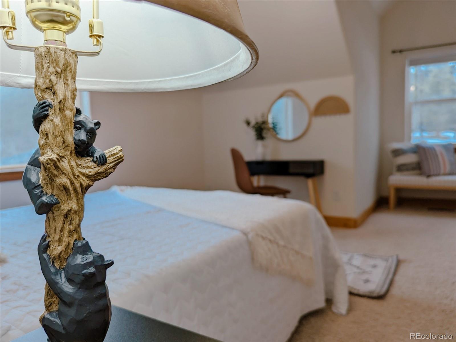 20133 Silver Ranch Road Conifer, CO 80433 - Photo 24 of 40 a bedroom with a bed and a chandelier
