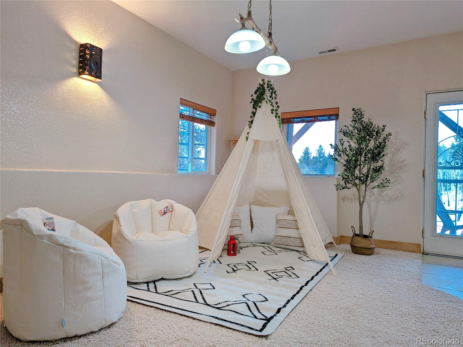 20133 Silver Ranch Road Conifer, CO 80433 - Photo 26 of 40 a living room with furniture and a chandelier