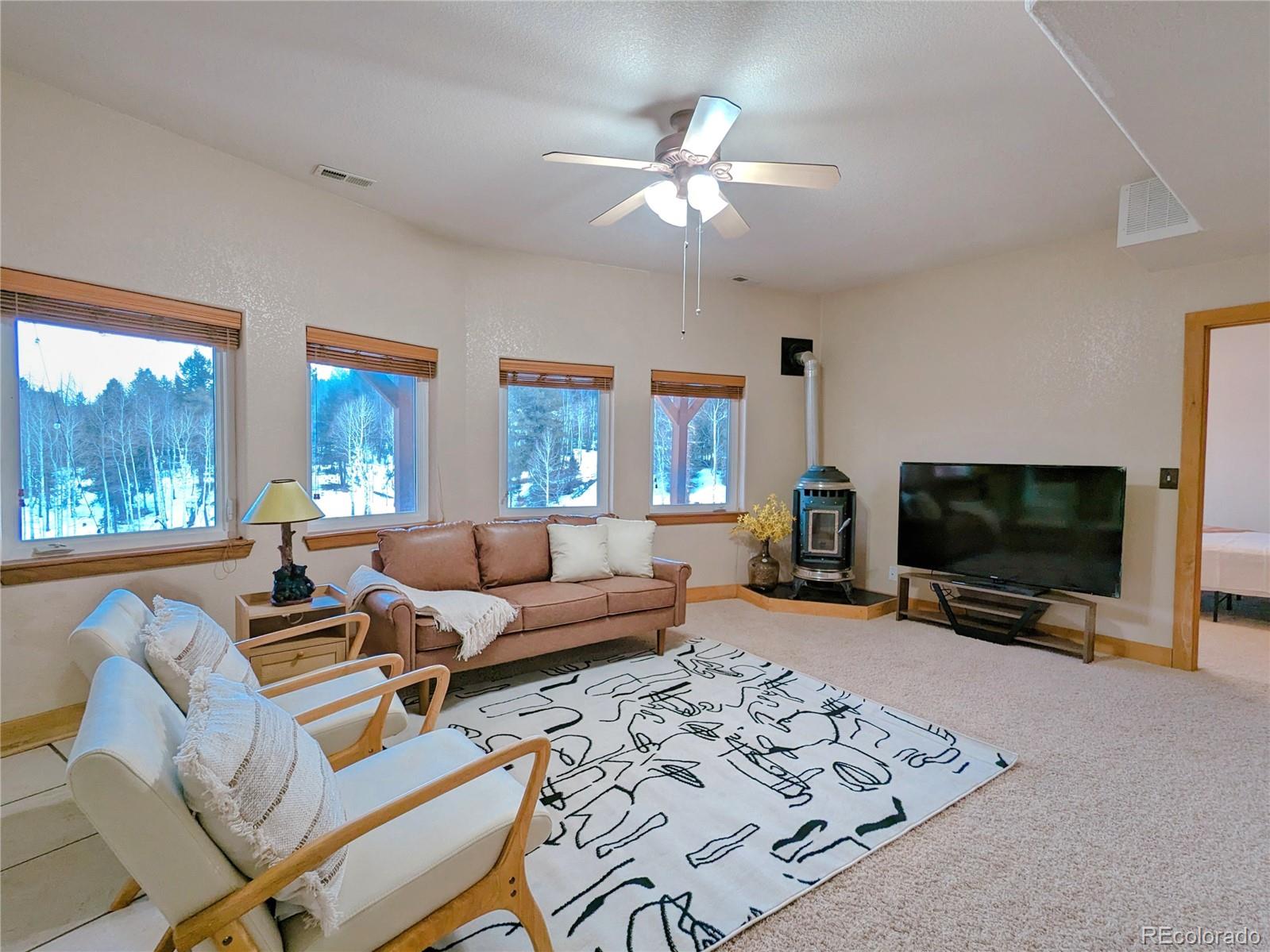 20133 Silver Ranch Road Conifer, CO 80433 - Photo 27 of 40 a living room with furniture and a flat screen tv