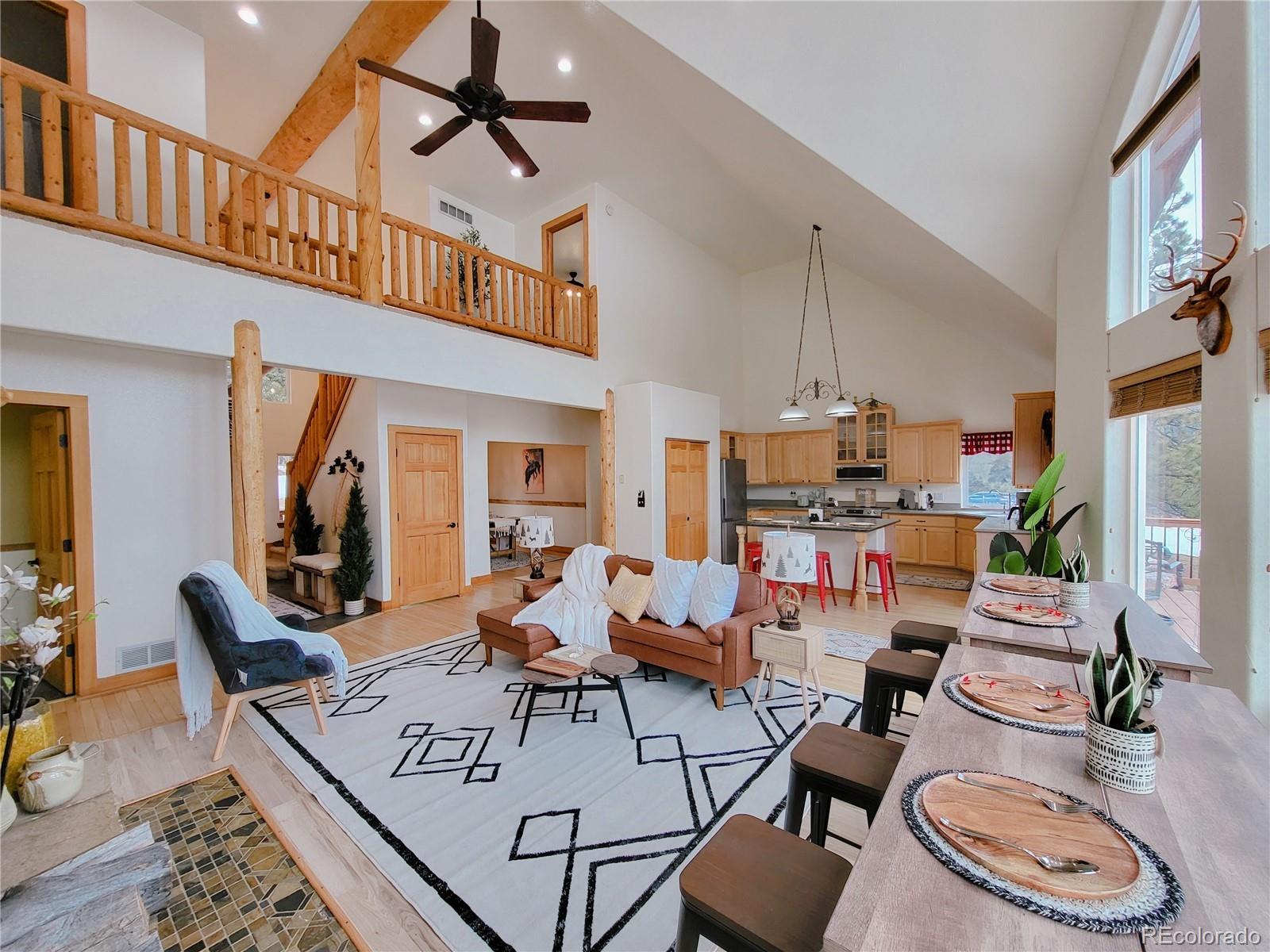 20133 Silver Ranch Road Conifer, CO 80433 - Photo 3 of 40 a living room with furniture a rug and a chandelier