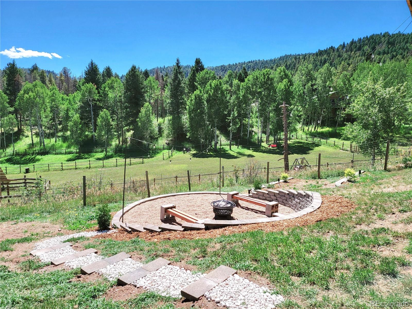 20133 Silver Ranch Road Conifer, CO 80433 - Photo 36 of 40 a table and chairs sitting in the middle of a park