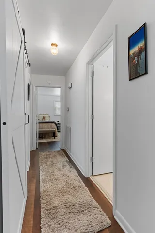 a view of a hallway with stairs and wooden floor