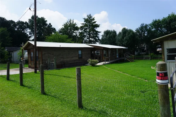 a view of a backyard with wooden fence and a bench
