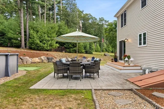a view of a patio with table and chairs under an umbrella