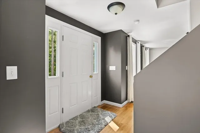 a view of hallway with stairs and wooden floor