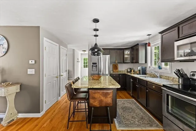 a kitchen with stainless steel appliances granite countertop sink stove top oven table and chairs