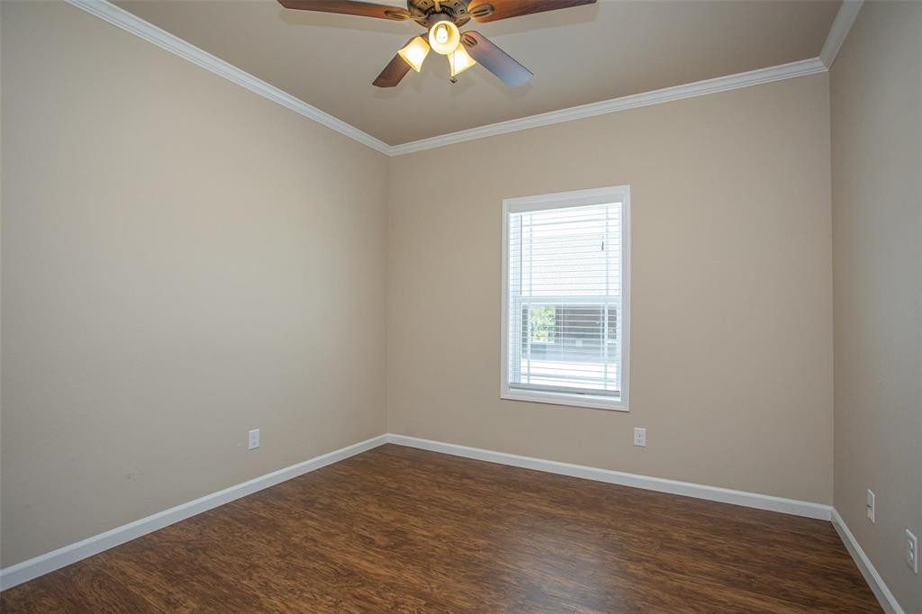 455 Neals Hill Road Oak Ridge, TX 76240 - Photo 17 of 19 Unfurnished room featuring crown molding, dark wood-type flooring, and ceiling fan