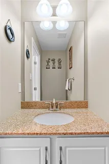 a bathroom with a granite countertop sink and a mirror