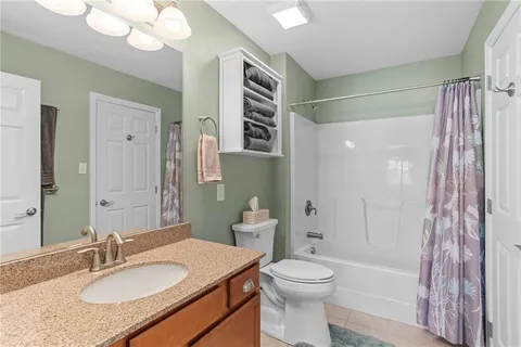 a bathroom with a granite countertop sink toilet a mirror a bathtub and shower